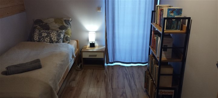 Przytulny pokój z łóżkiem i biblioteczką